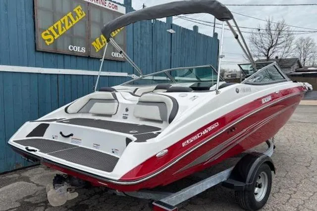 Slide: The Image of 2015 Yamaha Boats SX192 in red and white on trailer, parked outdoors. - 3