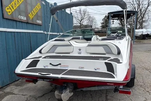 Slide: The Image of 2015 Yamaha Boats SX192 with bimini top, displayed outdoors near a marine shop. - 4