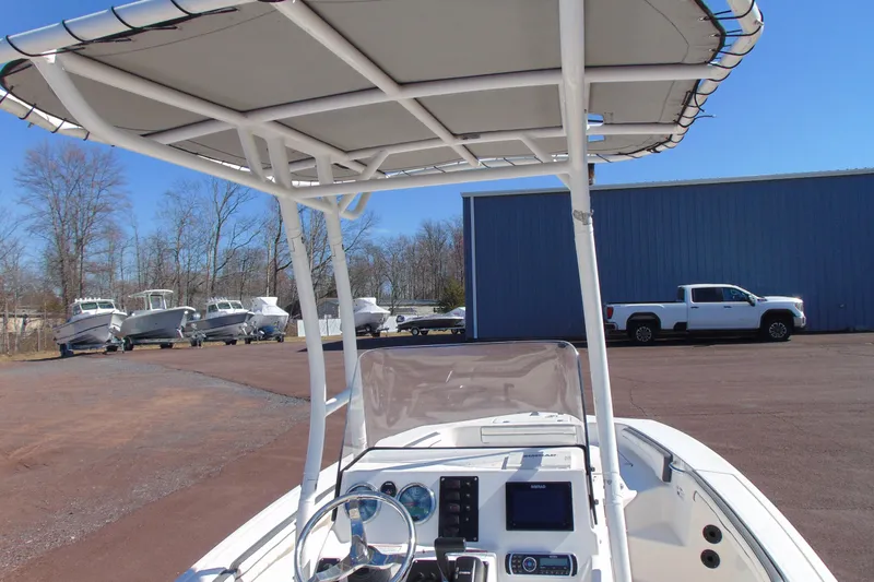 Slide: The Image of 2016 Yamaha Boats 190 FSH Sport with T-top and console, parked outdoors. - 8