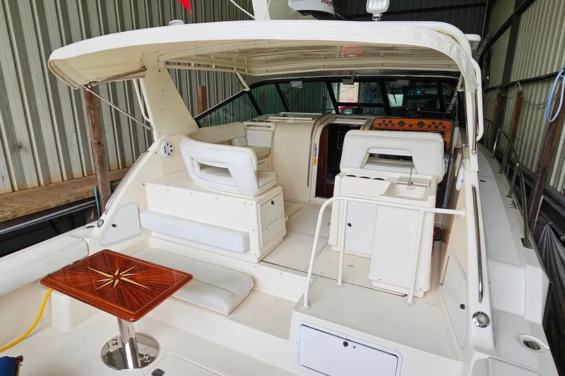 Slide: The Image of 1996 Tiara Yachts 4300 Open interior with seating and wooden table in a covered dock. - 10
