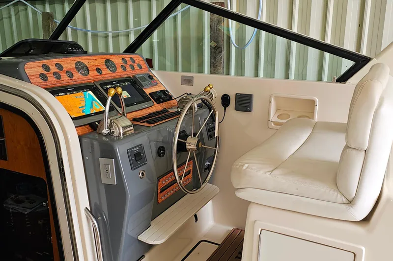 Slide: The Image of Helm of 1996 Tiara Yachts 4300 Open with navigation equipment and plush seating. - 18