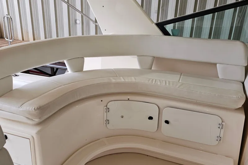 Slide: The Image of 1996 Tiara Yachts 4300 Open interior seating with white cushions and storage compartments. - 21