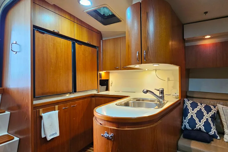 Slide: The Image of Luxurious 1996 Tiara Yachts 4300 Open interior with elegant wood cabinetry and modern kitchen amenities. - 28