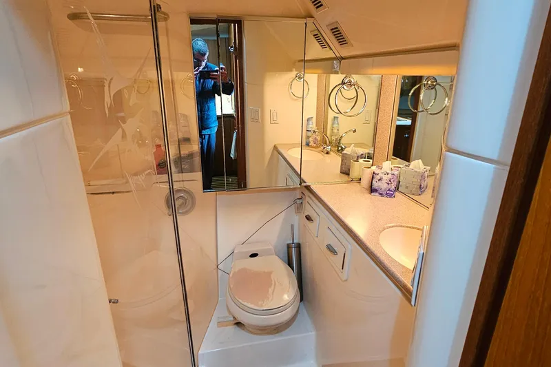 Slide: The Image of Bathroom interior of a 1996 Tiara Yachts 4300 Open, featuring a toilet and mirrored vanity. - 37