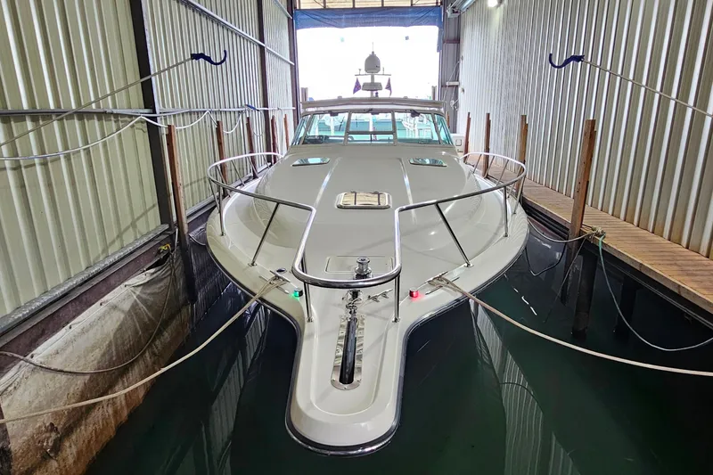 Slide: The Image of 1996 Tiara Yachts 4300 Open docked in a covered marina slip. - 4