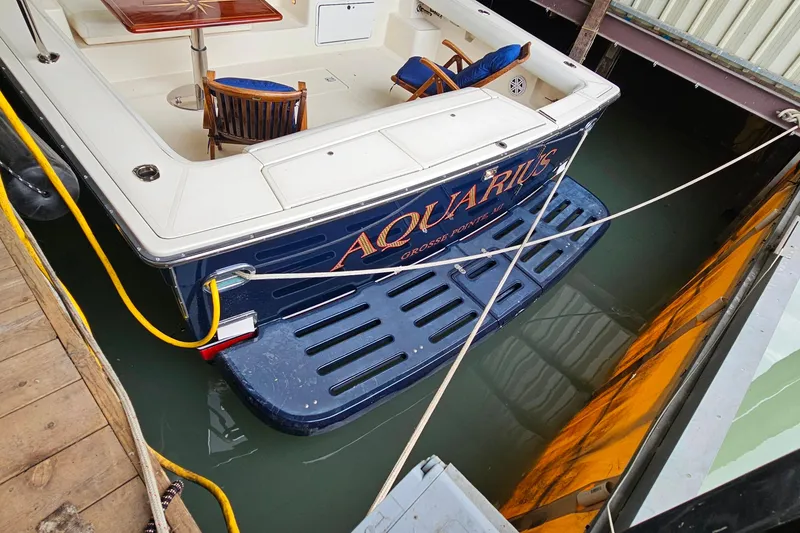 Slide: The Image of 1996 Tiara Yachts 4300 Open docked, featuring a spacious deck and elegant seating. - 6