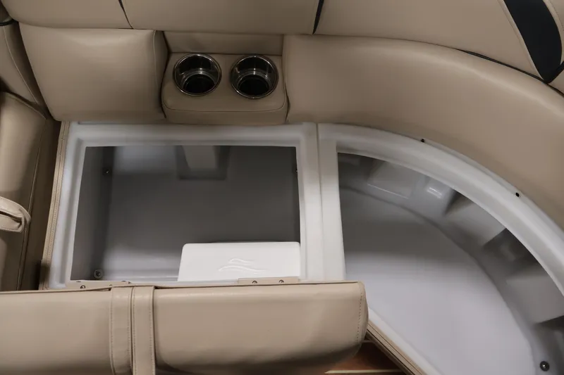 Slide: The Image of 2016 Berkshire 23E STS boat interior storage compartment with cup holders and beige seating. - 14