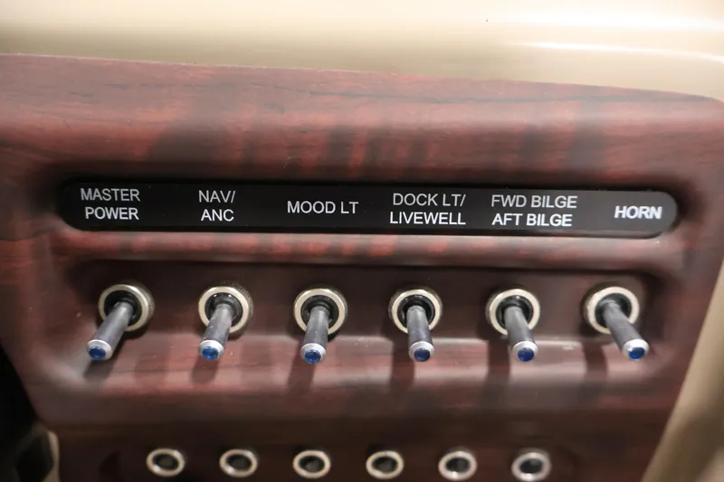 Slide: The Image of Control panel of a 2016 Berkshire 23E STS boat with labeled switches. - 27