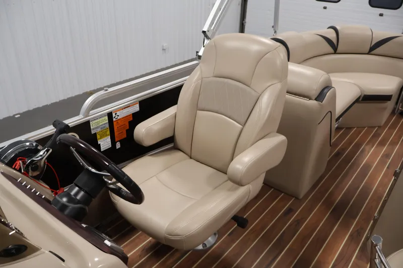 Slide: The Image of 2016 Berkshire 23E STS boat interior with beige captain's chair and wood flooring. - 29