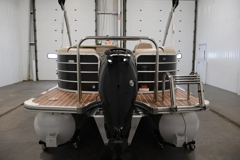 Slide: The Image of 2016 Berkshire 23E STS pontoon boat in a garage, rear view with motor and ladder. - 6