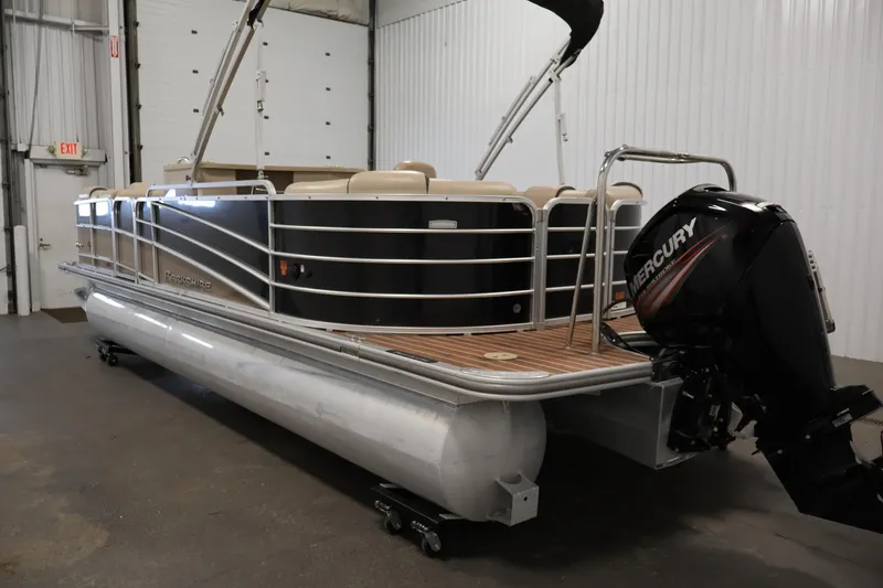 Slide: The Image of 2016 Berkshire 23E STS pontoon boat with Mercury outboard motor in a garage setting. - 7