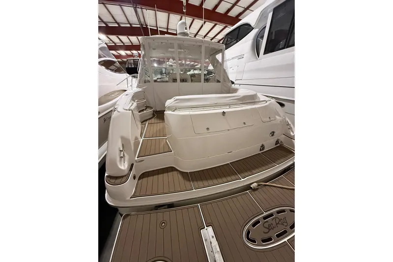 Slide: The Image of 2000 Sea Ray Sundancer 540 yacht in a marina, showcasing sleek design and spacious deck. - 2