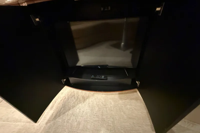 Slide: The Image of TV and remote inside a cabinet on a 2000 Sea Ray Sundancer 540 yacht. - 35