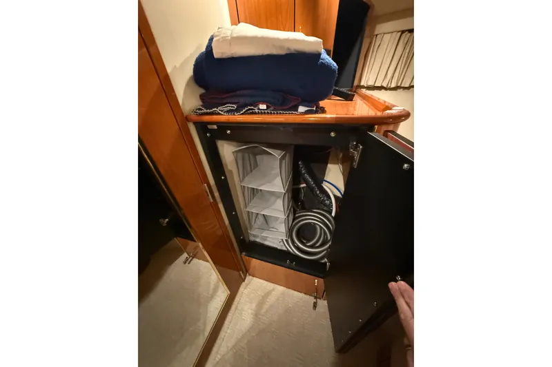 Slide: The Image of Storage cabinet on 2000 Sea Ray Sundancer 540 yacht with folded linens and coiled cables. - 38