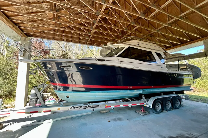 The Image of 2016 Cutwater C-30 CB boat on trailer under a wooden shelter. - 0