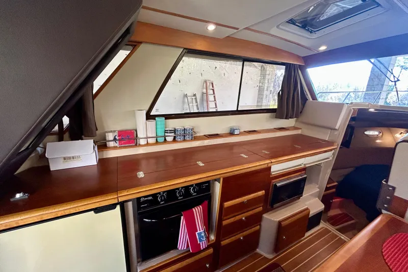 Slide: The Image of 2016 Cutwater C-30 CB interior with wooden cabinetry and modern kitchen appliances. - 16