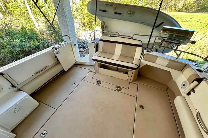 Slide: The Image of 2016 Cutwater C-30 CB boat interior with seating and storage, surrounded by greenery. - 25