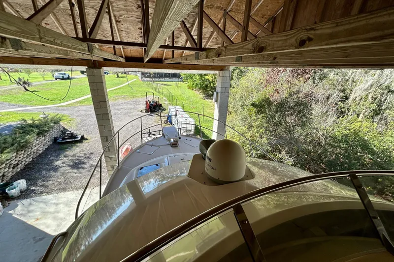 Slide: The Image of 2016 Cutwater C-30 CB boat under wooden shelter, surrounded by greenery. - 33
