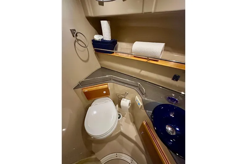 Slide: The Image of 2016 Cutwater C-30 CB yacht bathroom with toilet, sink, and storage shelves. - 10