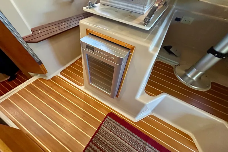 Slide: The Image of Interior of 2016 Cutwater C-30 CB boat with wood flooring and compact fridge. - 20