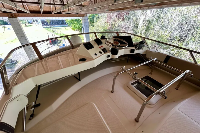 Slide: The Image of 2016 Cutwater C-30 CB boat helm with steering wheel and control panel under a wooden roof. - 32