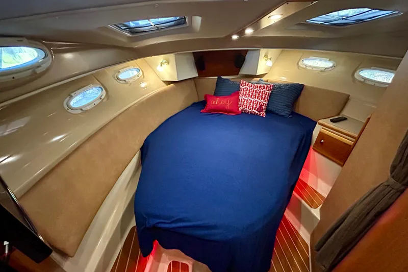 Slide: The Image of Cozy cabin interior of 2016 Cutwater C-30 CB with blue bedding and decorative pillows. - 6