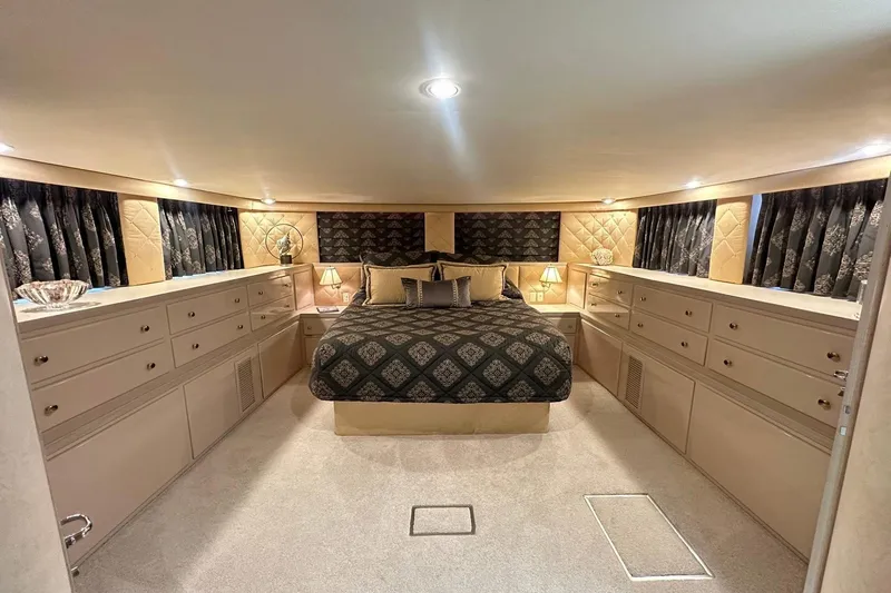 Slide: The Image of Luxurious bedroom interior of 1992 Hatteras 65 Motor Yacht with elegant decor and ample storage. - 12