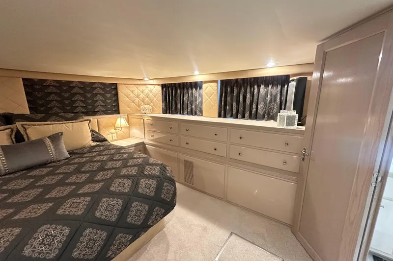 Slide: The Image of Luxurious bedroom interior of 1992 Hatteras 65 Motor Yacht with elegant bedding and cabinetry. - 13