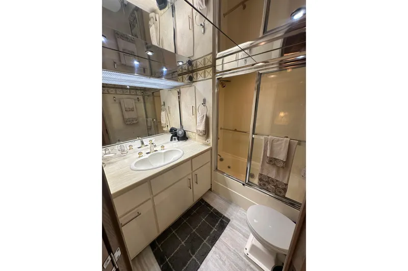 Slide: The Image of Luxurious bathroom in a 1992 Hatteras 65 Motor Yacht with elegant fixtures and mirrored walls. - 15