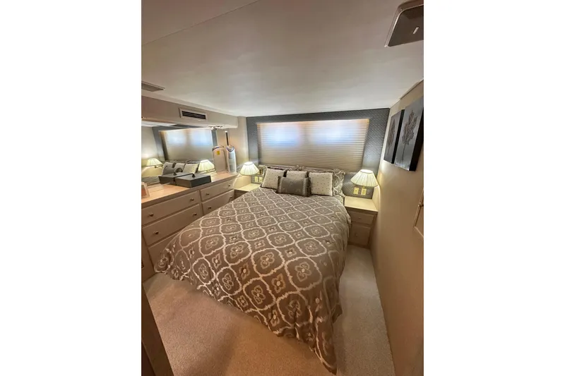 Slide: The Image of Cozy bedroom interior of 1992 Hatteras 65 Motor Yacht with elegant bedding and soft lighting. - 19