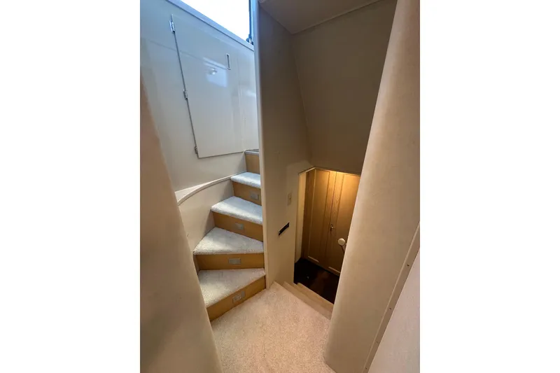 Slide: The Image of Interior staircase of 1992 Hatteras 65 Motor Yacht, featuring carpeted steps and sleek design. - 22