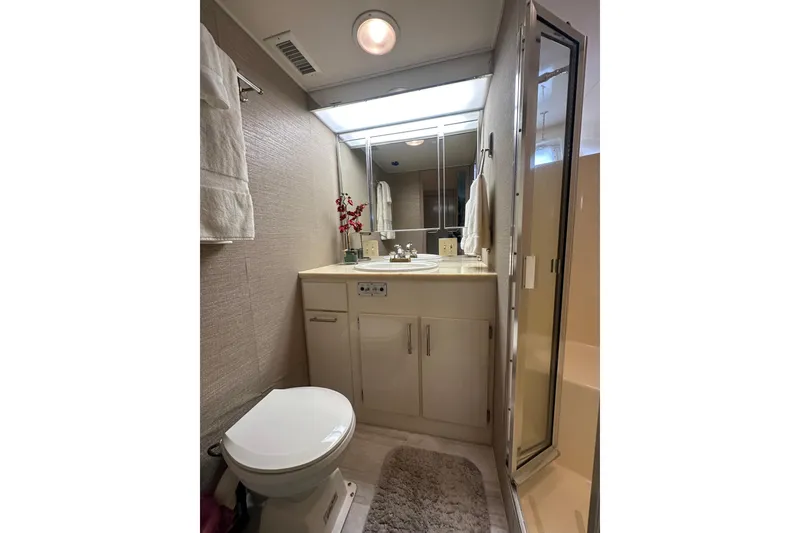 Slide: The Image of Bathroom interior of 1992 Hatteras 65 Motor Yacht, featuring sink, toilet, and shower. - 29