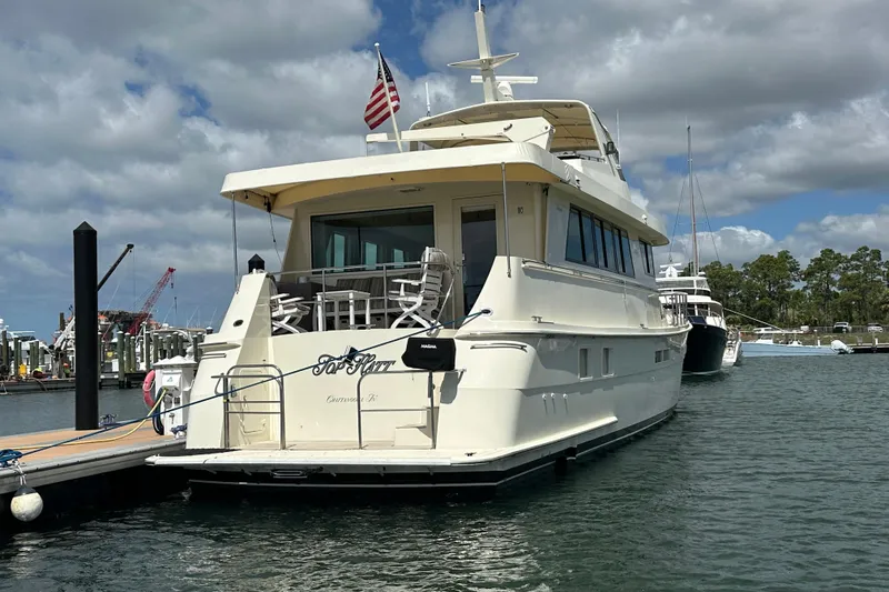 Slide: The Image of 1992 Hatteras 65 Motor Yacht docked at marina under cloudy sky. - 3