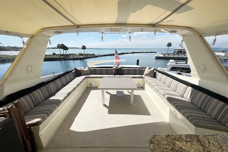 Slide: The Image of Luxurious 1992 Hatteras 65 Motor Yacht deck with seating, table, and ocean view. - 31