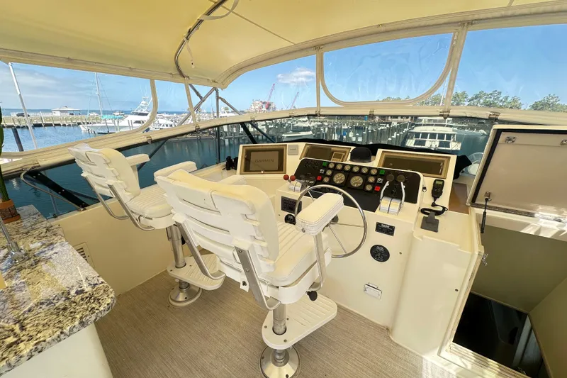 Slide: The Image of Bridge of 1992 Hatteras 65 Motor Yacht with helm controls and seating. - 32