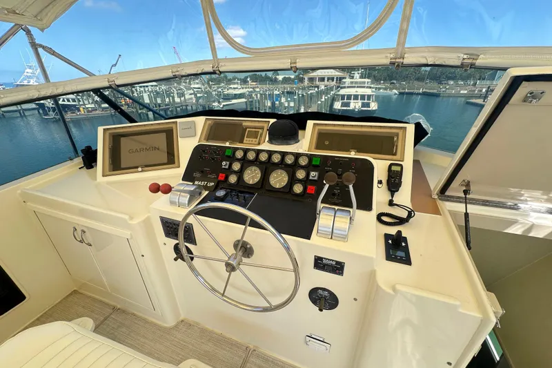 Slide: The Image of Cockpit of 1992 Hatteras 65 Motor Yacht with navigation equipment and marina view. - 34
