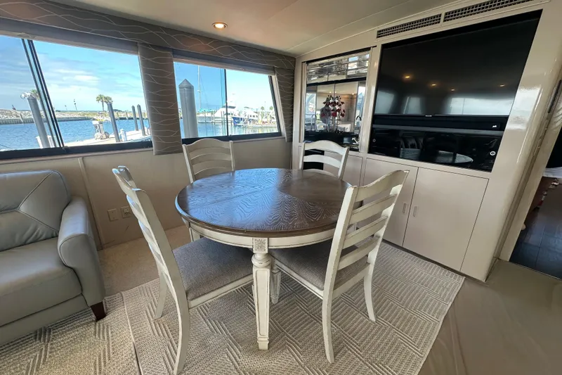 Slide: The Image of Interior of 1992 Hatteras 65 Motor Yacht with dining table and waterfront view. - 7