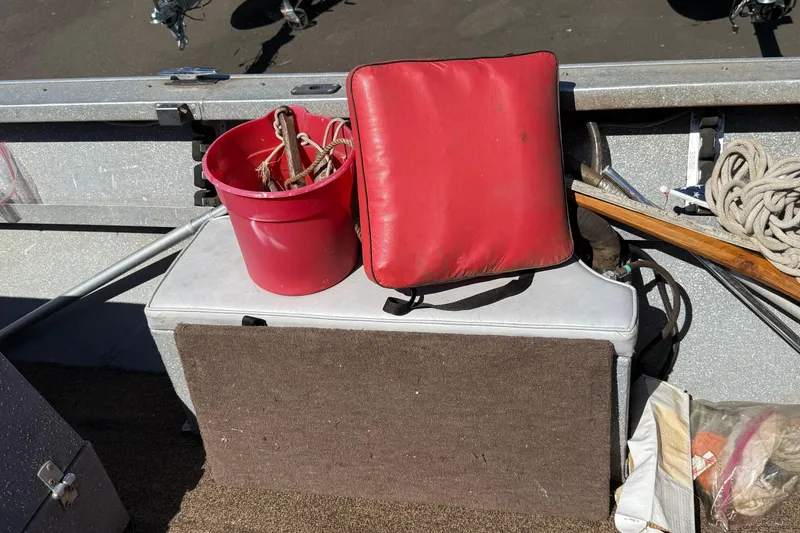 Slide: The Image of 1977 Alumaweld Inboard Jet boat interior with red bucket, cushion, and rope. - 11