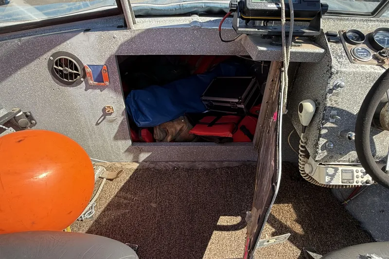Slide: The Image of 1977 Alumaweld Inboard Jet boat interior with storage compartment and equipment. - 16