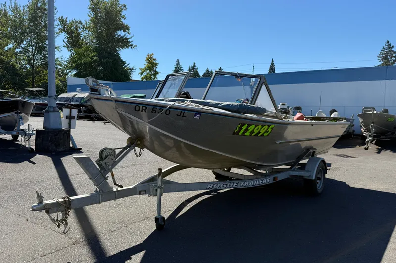Slide: The Image of 1977 Alumaweld Inboard Jet boat on trailer, priced at $12,995, parked outdoors. - 3