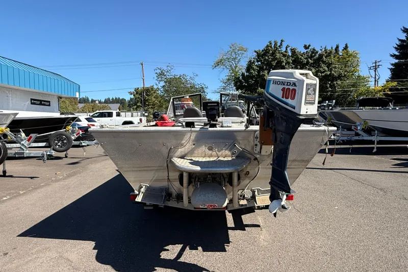 Slide: The Image of 1977 Alumaweld Inboard Jet boat with Honda 100 outboard motor in a parking lot. - 5