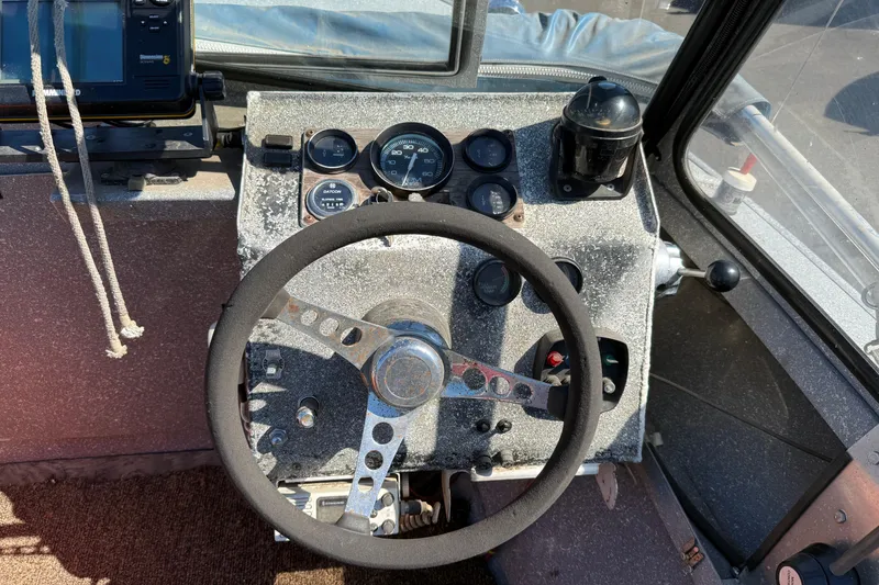 Slide: The Image of 1977 Alumaweld Inboard Jet boat dashboard with steering wheel and gauges. - 6