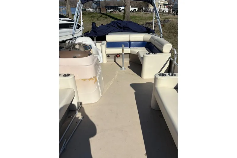 Slide: The Image of 2006 Triton 220 F Gold boat interior with beige seating and steering console. - 4