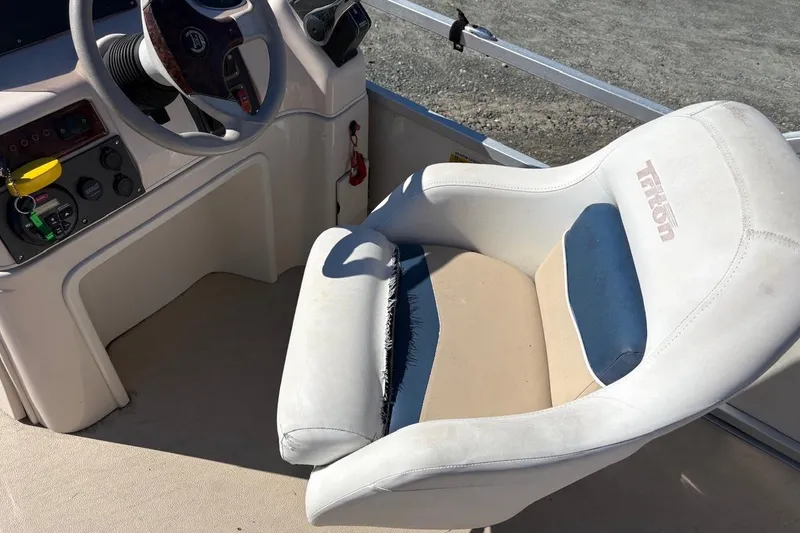 Slide: The Image of Captain's seat and controls of a 2006 Triton 220 F Gold boat. - 5