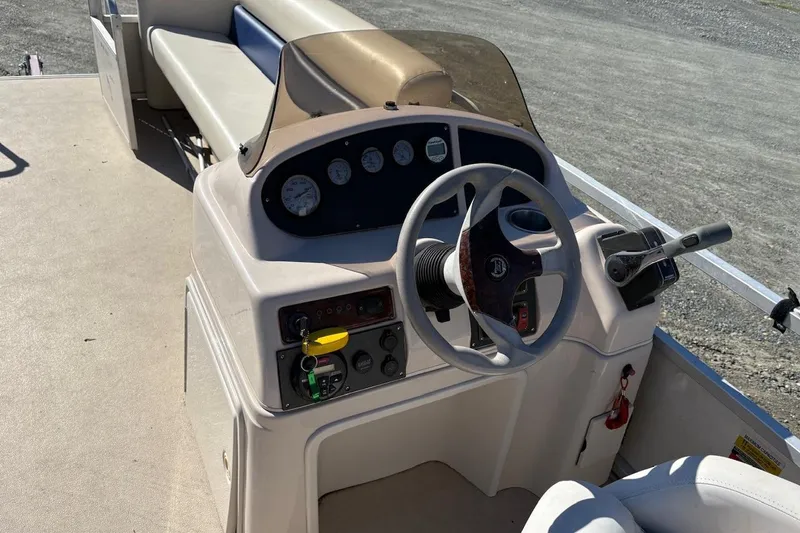 Slide: The Image of Steering console of a 2006 Triton 220 F Gold boat with gauges and controls. - 6
