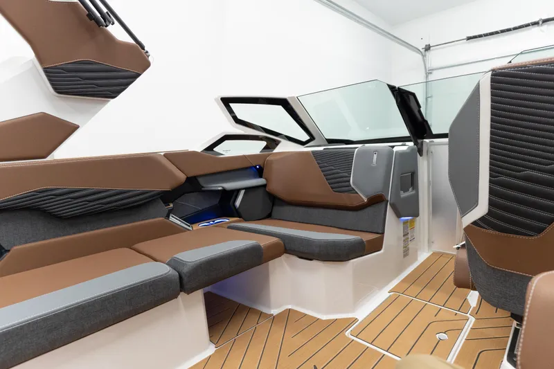 Slide: The Image of 2026 MasterCraft X24 boat interior with brown and gray seating, modern design, and wood-style flooring. - 11