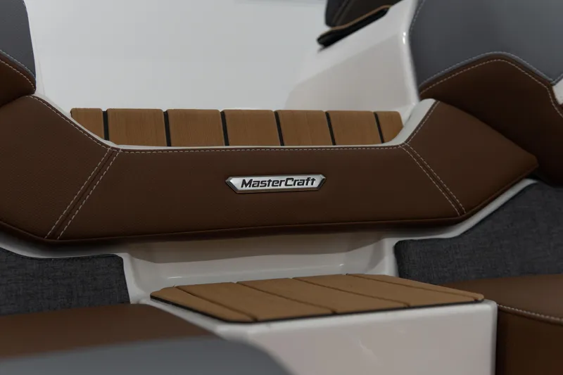 Slide: The Image of 2026 MasterCraft X24 boat interior with brown and gray seating. - 18