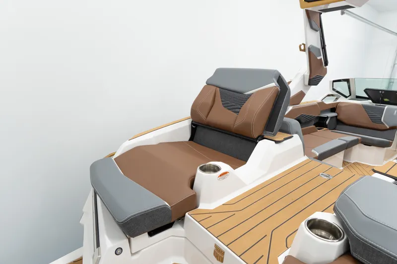 Slide: The Image of 2026 MasterCraft X24 boat interior with brown and gray seating, cup holders, and sleek design. - 19