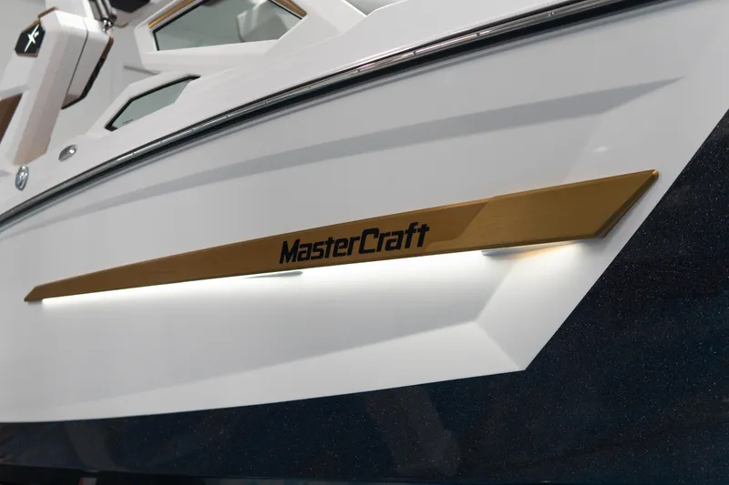 Slide: The Image of 2026 MasterCraft X24 boat with sleek design and gold accent detail. - 24