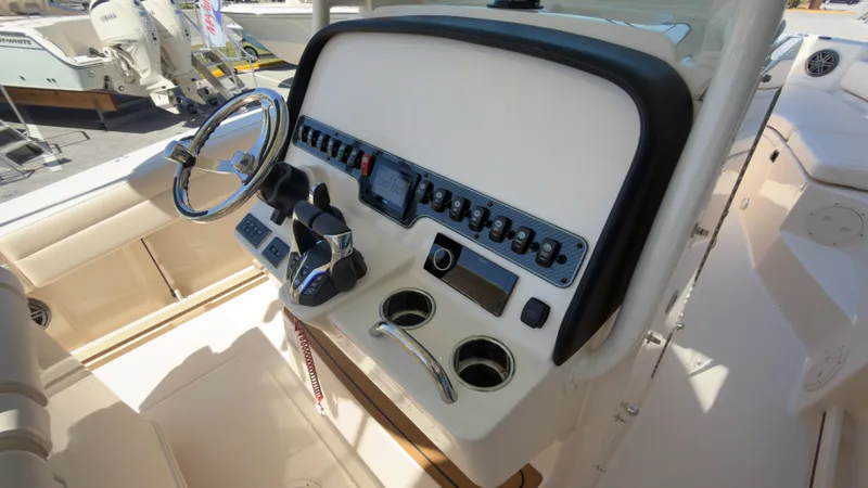Slide: The Image of The image shows the helm of a Grady-White Canyon 266 boat with modern controls. - 23